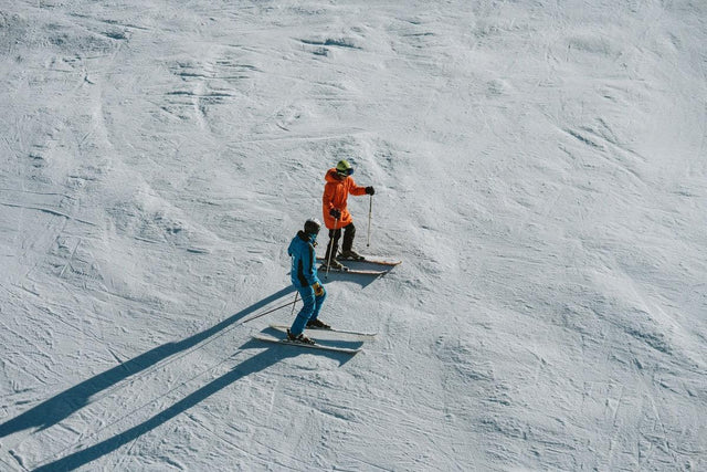 Skilehrer erklärt einem Schüler die Technik auf einer Piste in Baqueira