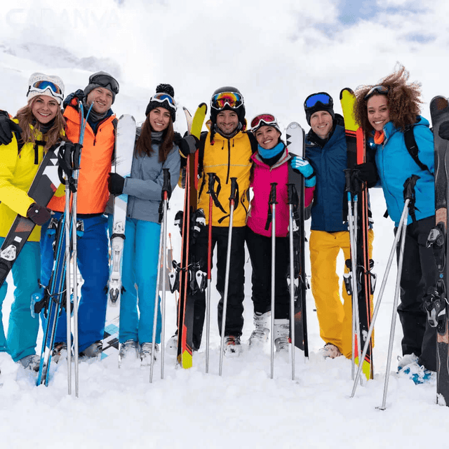 Gruppe von Freunden, die lächelnd mit Ski und Stöcken im Schnee stehen